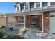 Charming front porch featuring brick accents and a cozy sitting area with ample natural light at 7773 Gunsight Pass, Littleton, CO 80127