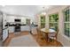 Eat-in kitchen features white cabinets, black counters, stainless appliances, and backyard views at 7773 Gunsight Pass, Littleton, CO 80127