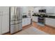 Bright eat-in kitchen features modern stainless steel appliances, white cabinets and hardwood floors at 7773 Gunsight Pass, Littleton, CO 80127
