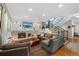 Stylish living room featuring a fireplace, built-in shelving, and easy access to the staircase at 7773 Gunsight Pass, Littleton, CO 80127