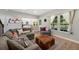 Bright living room featuring hardwood floors, large windows, and an open view to the kitchen at 7773 Gunsight Pass, Littleton, CO 80127