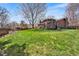 Expansive backyard showcasing lush green grass, a deck, and mature trees, perfect for outdoor activities at 8320 W Harvard Dr, Lakewood, CO 80227