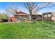 Expansive backyard with lush lawn, mature trees, a deck, hot tub and gazebo at 8320 W Harvard Dr, Lakewood, CO 80227