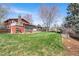 Large backyard with well-maintained lawn, mature trees, deck with hot tub, and outdoor seating at 8320 W Harvard Dr, Lakewood, CO 80227