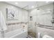 Bright bathroom with shower over tub, featuring neutral tiles and stone flooring in the shower at 8320 W Harvard Dr, Lakewood, CO 80227