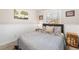 Cozy bedroom featuring a comfortable bed, wainscoting, a window, and tasteful decorations at 8320 W Harvard Dr, Lakewood, CO 80227