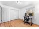 Bedroom with hardwood floors, closet, and a modern desk setup by the window at 8320 W Harvard Dr, Lakewood, CO 80227