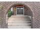 Charming front entrance with an arched brick frame, updated black doors, and decorative wreath at 8320 W Harvard Dr, Lakewood, CO 80227