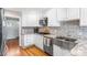 Updated kitchen showcasing granite countertops, stainless steel appliances, and tiled backsplash at 8320 W Harvard Dr, Lakewood, CO 80227