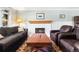 Comfortable living room with fireplace and cozy seating: a sofa and two leather armchairs at 8320 W Harvard Dr, Lakewood, CO 80227