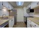 Galley kitchen with stainless steel appliances, white cabinets, and a skylight providing natural light at 3494 S Eagle St # 202, Aurora, CO 80014