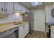Efficient kitchen featuring stainless steel appliances, white cabinets, and neutral countertops with overhead skylight at 3494 S Eagle St # 202, Aurora, CO 80014