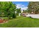 Large backyard featuring a cozy pergola, hot tub, mature trees, and ample green space at 3865 Independence Ct, Wheat Ridge, CO 80033