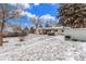 Large, snow-covered backyard with patio, hot tub, and storage shed at 3865 Independence Ct, Wheat Ridge, CO 80033