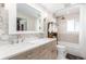 Updated bathroom with dual sink vanity, floral wallpaper, and shower-over-tub combination at 3865 Independence Ct, Wheat Ridge, CO 80033