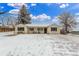 Charming home with snow-covered lawn, featuring black shutters and a welcoming front porch at 3865 Independence Ct, Wheat Ridge, CO 80033