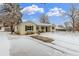 Well-maintained home with a wide driveway and a snow-covered front yard at 3865 Independence Ct, Wheat Ridge, CO 80033