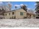 Rear exterior view with a patio cover and snow-covered ground on a sunny day at 3865 Independence Ct, Wheat Ridge, CO 80033