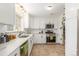 A well-lit kitchen with stainless steel appliances, including a microwave and range, white cabinets and tile flooring at 3865 Independence Ct, Wheat Ridge, CO 80033