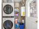 A compact laundry space with a stacked washer and dryer and organized storage shelves at 3865 Independence Ct, Wheat Ridge, CO 80033