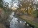 Beautiful view of a stream flowing through a wooded area, highlighting the natural surroundings at 3865 Independence Ct, Wheat Ridge, CO 80033