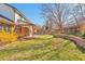 A lush, green backyard with a pergola, mature trees, and brick patio at 8055 S Zephyr Way, Littleton, CO 80128