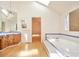 Bathroom view with tub, vanity, and an opening leading to another room with natural light at 8055 S Zephyr Way, Littleton, CO 80128