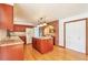 Spacious kitchen with an island, granite countertops, wood cabinets, and a stylish brick archway at 8055 S Zephyr Way, Littleton, CO 80128