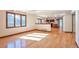 Sunlit living area with hardwood floors, large windows, and a seamless connection to the kitchen area at 8055 S Zephyr Way, Littleton, CO 80128
