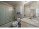 Clean bathroom featuring a shower over tub with glass doors and a vanity sink at 10441 W Remington Dr, Littleton, CO 80127