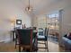 Stylish dining area with a glass-top table, modern light fixture, and sliding glass doors to the patio at 10441 W Remington Dr, Littleton, CO 80127
