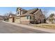 Two-story home with a three-car garage, stone accents, and well-maintained landscaping enhancing curb appeal at 10441 W Remington Dr, Littleton, CO 80127