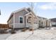 Two-story craftsman home with gray siding, snowy landscaping, and a two-car garage at 838 N Yantley St, Aurora, CO 80018