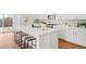 Modern kitchen with white cabinets, island with seating, and stainless steel appliances at 838 N Yantley St, Aurora, CO 80018