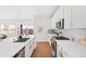 Modern kitchen with white cabinets, gray backsplash and stainless steel appliances at 838 N Yantley St, Aurora, CO 80018