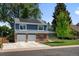 Beautiful home with a driveway leading to the two-car garage and solar panels, set against a backdrop of lush greenery at 3767 E Phillips Cir, Centennial, CO 80122