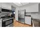 Kitchen featuring stainless steel appliances, white cabinets, and access to an adjacent dining space at 3767 E Phillips Cir, Centennial, CO 80122