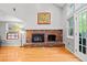 Living room featuring a brick fireplace, large windows, and hardwood floors at 3767 E Phillips Cir, Centennial, CO 80122