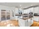 Bright kitchen boasting white cabinets, a center island with cooktop, and an adjacent deck at 22678 E Lake Pl, Centennial, CO 80015