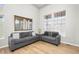 Bright living room featuring modern grey sofas, beautiful wood floors, large windows and a gold mirror at 22678 E Lake Pl, Centennial, CO 80015