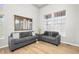 Bright living room featuring modern grey sofas, beautiful wood floors, large windows and a gold mirror at 22678 E Lake Pl, Centennial, CO 80015