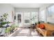 Bright sunroom with tile flooring, ample natural light, and multiple plants near the windows and wicker loveseat at 22678 E Lake Pl, Centennial, CO 80015