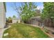 Green backyard featuring a storage shed, well-maintained lawn, and a wooden fence, offering ample space at 4856 S Quintero Cir, Aurora, CO 80015