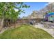 Well-manicured backyard with a spacious lawn, stone patio, comfortable seating, and a wooden fence at 4856 S Quintero Cir, Aurora, CO 80015