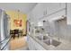 Modern kitchen with stainless appliances, white cabinets, and open dining area at 4856 S Quintero Cir, Aurora, CO 80015