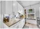 Updated kitchen with white cabinets, granite countertops, and stainless steel sink at 4856 S Quintero Cir, Aurora, CO 80015