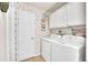 Functional laundry room with washer, dryer and storage cabinets at 4856 S Quintero Cir, Aurora, CO 80015