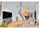 Open-concept living space with modern lighting, stairs, and dining area at 4856 S Quintero Cir, Aurora, CO 80015