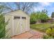 Backyard storage shed with charming doors and well-kept lawn, perfect for storing gardening equipment and tools at 4856 S Quintero Cir, Aurora, CO 80015