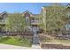 Inviting two-story townhome featuring manicured landscaping and a charming brick facade on a sunny day at 9182 Ridgegate Pkwy, Lone Tree, CO 80124